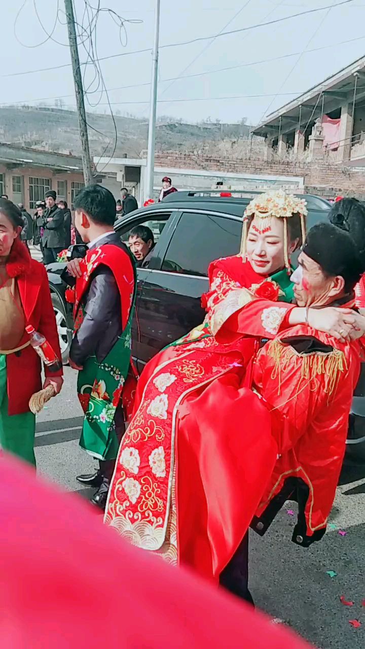 新郎在一旁站着,公公抱着新娘下车,你们能接受这样的习俗吗?
